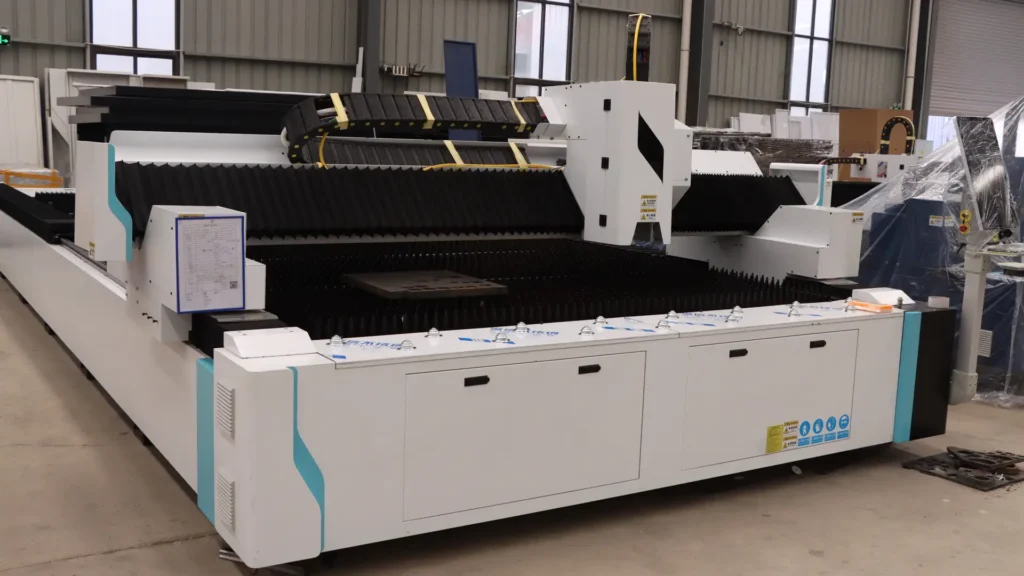 Large format laser cutting system with dual-drive gantry and heavy-duty exchange table processing oversized thick steel plate in industrial fabrication workshop