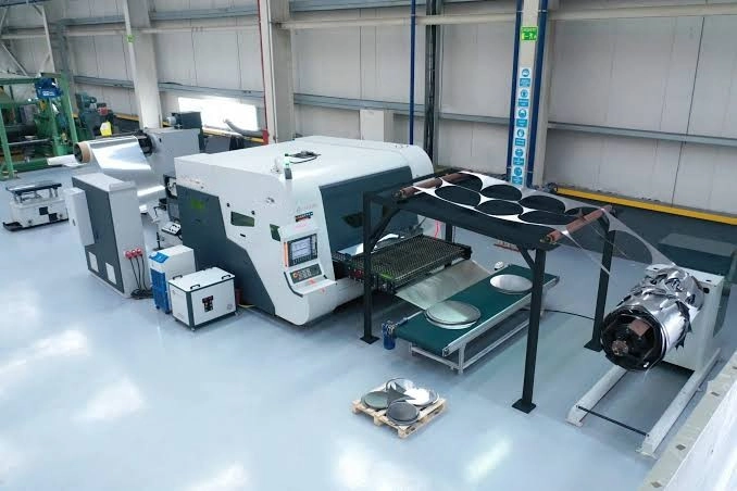 Complete coil-fed laser cutting production line in industrial workshop with automated decoiler and leveler