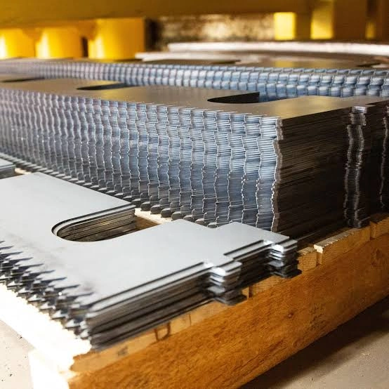 Neatly stacked laser cut sheet metal parts on wooden pallets ready for downstream transfer in fabrication facility