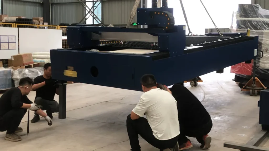 Industrial rigging crew delivering and unloading a new fiber laser cutting machine