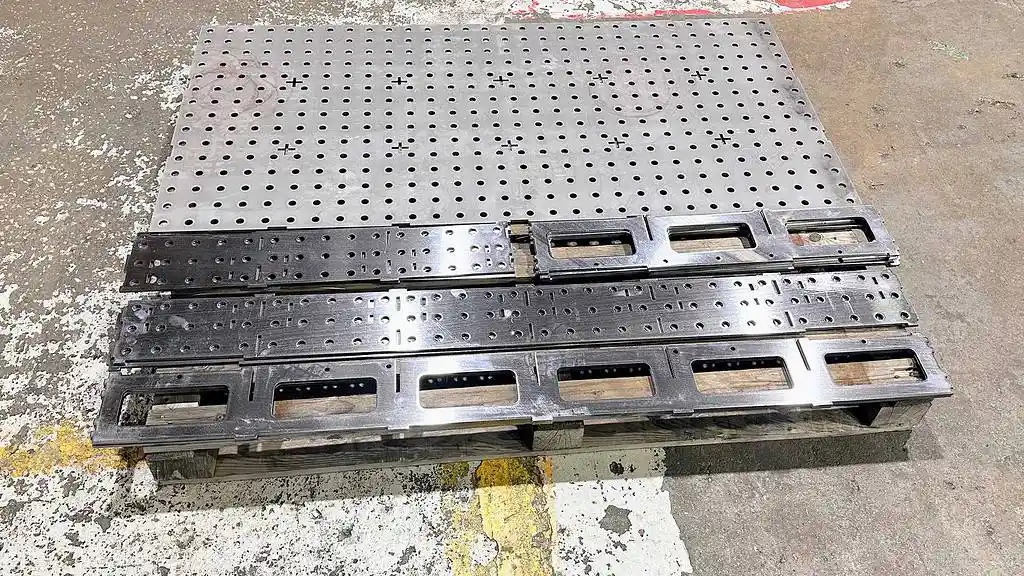 Quality control inspector checking delivered laser cut parts on a wooden pallet