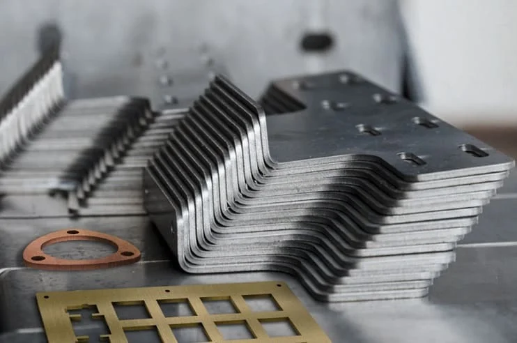 Stack of finished laser-cut steel parts ready for delivery