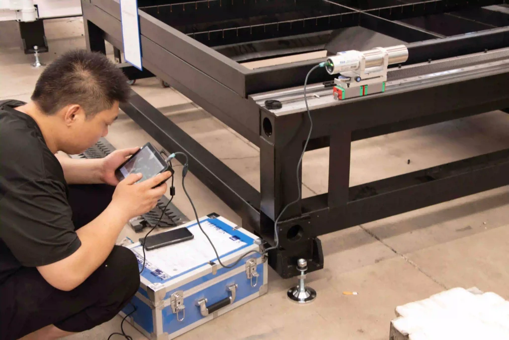 Technician testing linear guide rail straightness and bed alignment on a fiber laser machine