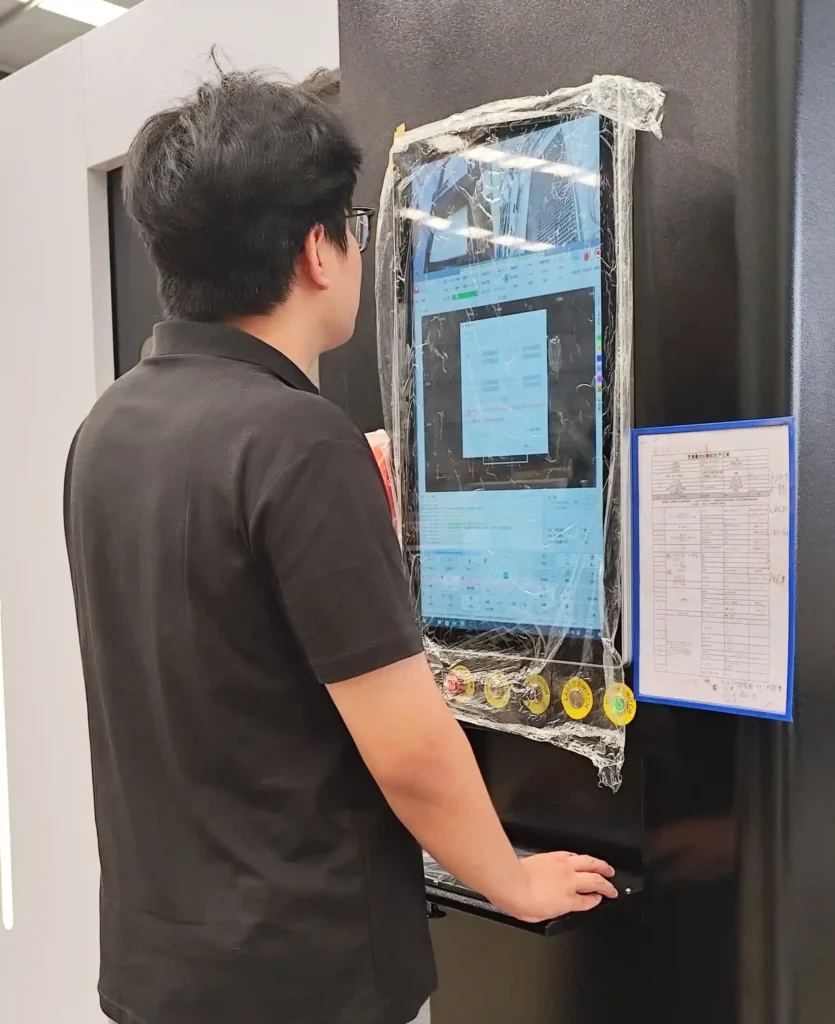 Machine operator configuring cutting parameters on a laser CNC touchscreen