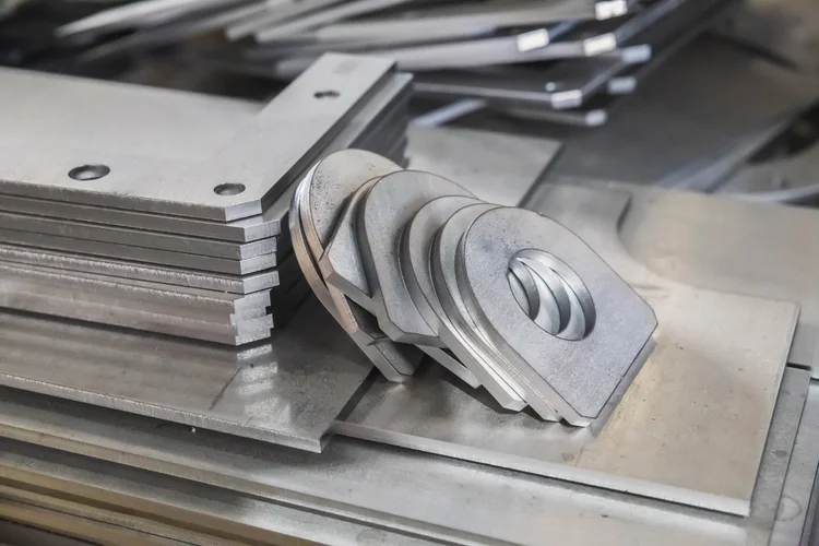 Pallet of mass-produced identical laser-cut steel parts in a fabrication shop
