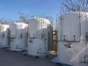 Bulk liquid oxygen and liquid nitrogen storage tanks with ambient vaporizers installed outside a fabrication workshop