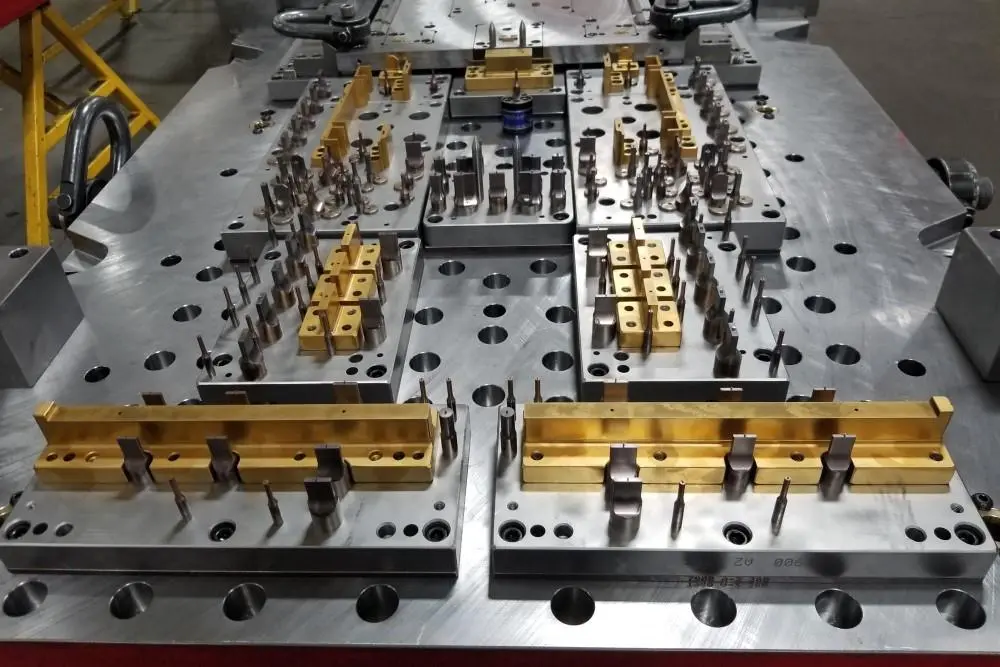 Close-up of a multi-stage progressive stamping die showing high-precision guide pillars and blanking stations